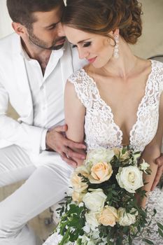 Chic wedding couple groom and bride posing in a white Studio.