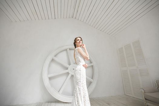 Beautiful bride posing in wedding dress in a white photo Studio.