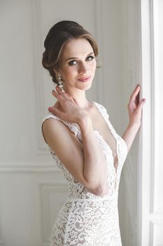 Beautiful bride posing in wedding dress in a white photo Studio.