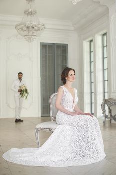 Chic wedding couple groom and bride posing in a white Studio.