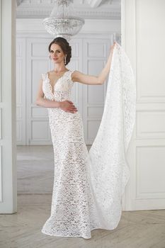 Beautiful bride posing in wedding dress in a white photo Studio.