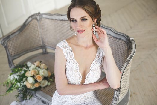 Beautiful bride posing in wedding dress in a white photo Studio.