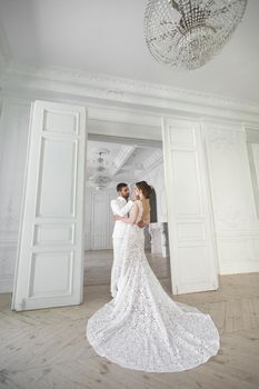 Chic wedding couple groom and bride posing in a white Studio.