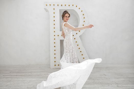 Beautiful bride posing in wedding dress in a white photo Studio.