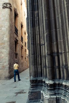 men's figure blurred by motion on narrow street in famous  Gothic Quarter in Barcelona