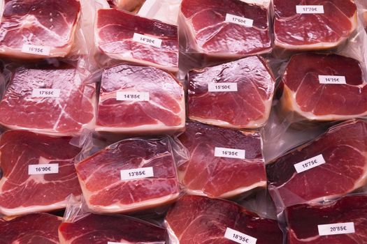 packed  sun-dried ham pieces on market counter in Spain