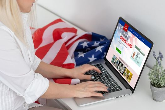 Green card in a search engine on the computer. laptop and american flag.