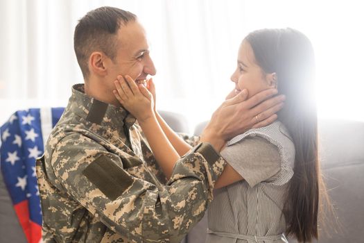 Soldier with flag of USA and his little daughter hugging, space for text.