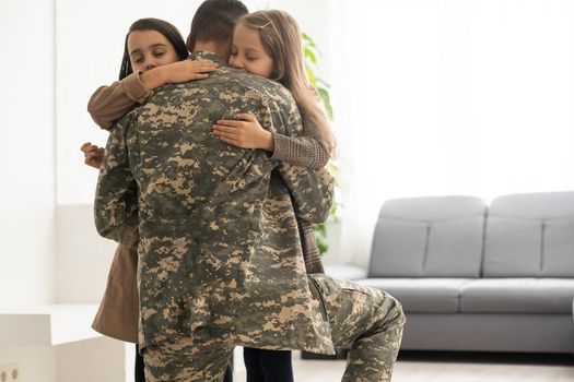 Happy military father and two daughters at home