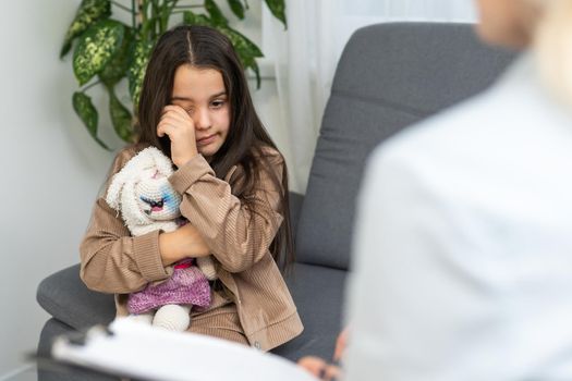 Young child psychologist working with little girl.
