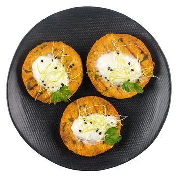 Grilled veggie burgers with chickpeas and vegetables and parsley leaves on ceramic plate isolated on white background.