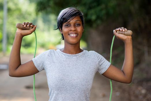 young girl jumping rope smiling.