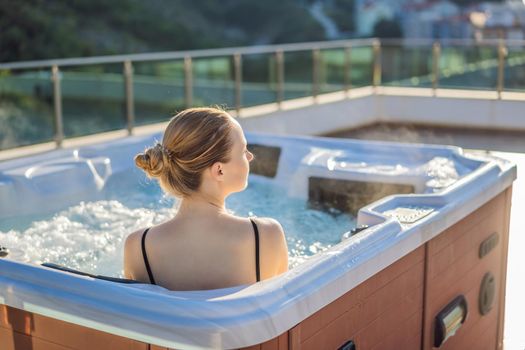 Portrait of young carefree happy smiling woman relaxing at hot tub during enjoying happy traveling moment vacation life against the background of green big mountains.