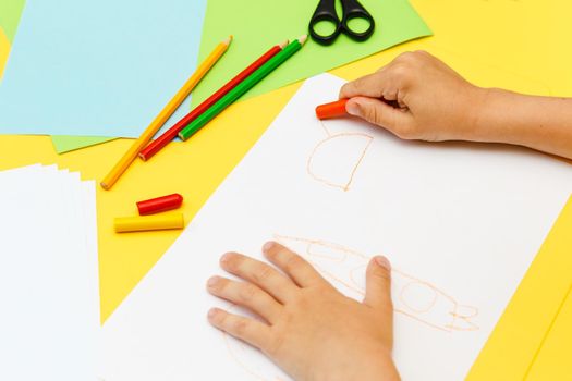 Indoor activity. Top view of kid's hands paiting with crayons. Indoor activity