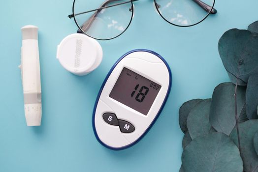 Close up of diabetic measurement tools and pills on pink background .