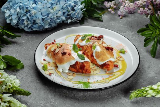 croissant with sweet cream and almonds on a plate. Delicious and healthy breakfast.