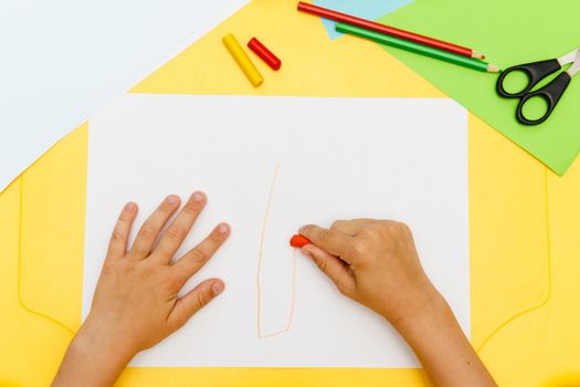 Indoor activity. Top view of kid's hands paiting with crayons. Indoor activity