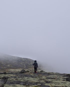 A young girl in the mountains goes into the clouds. dense clouds. photo