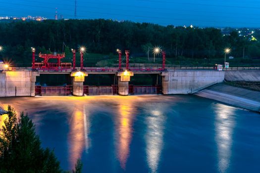 River,dam,bridge in the evening.Car and pedestrian bridge at night. A full-flowing river with a strong current.Clean,bubbling,fresh water.Technical construction on the river, fresh water reserves.