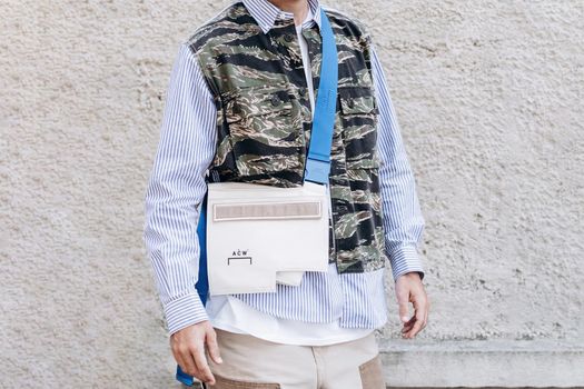 Milan, Italy - September 24, 2021: street style fashion outfit details, man wearing striped shirt and military belt