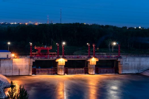 River,dam,bridge in the evening.Car and pedestrian bridge at night. A full-flowing river with a strong current.Clean,bubbling,fresh water.Technical construction on the river, fresh water reserves.