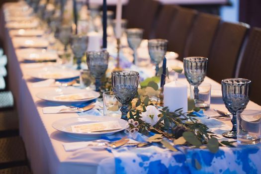 Wedding banquet. Table setting with blue glasses