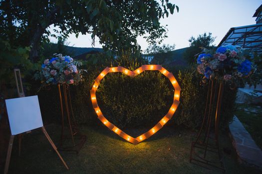 Handmade heart illuminated by light bulbs at a wedding