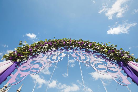 Wedding arch of purple color on the background of the sea.