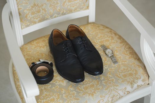 Accessories for the groom. Wedding shoes on a chair