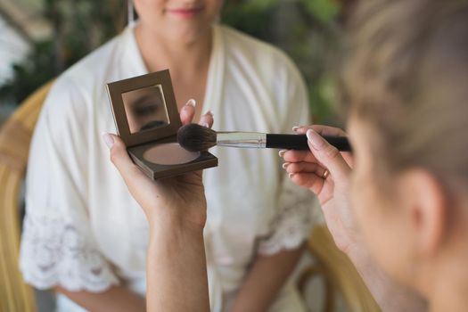 The stylist does the bride's makeup in the morning.