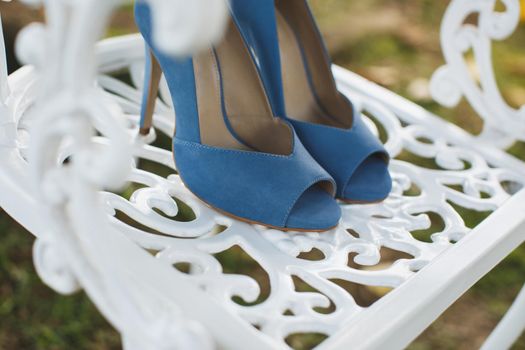 Women's shoes on a white chair on the wedding day.