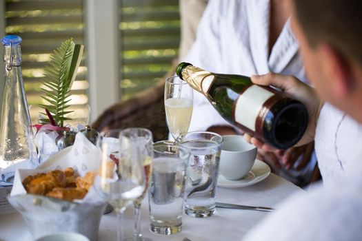 A man pours champagne in a glass