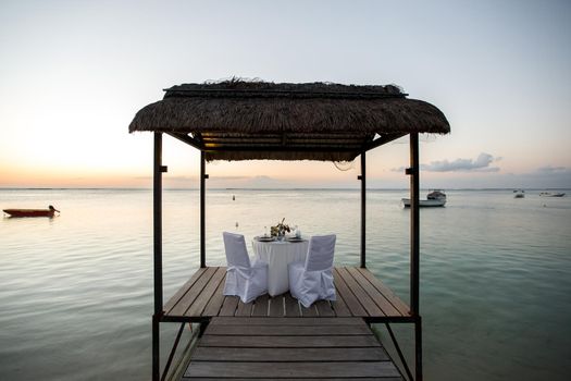 Romantic dinner setting on the beach at sunset