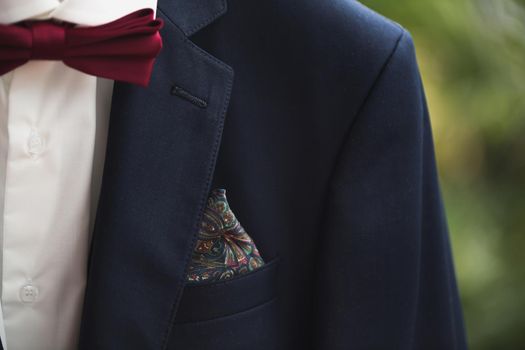Closeup of elegant formal business suit with dark grey jacket with handkerchief in the pocket shirt and necktiev