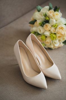 The bride's wedding accessories: shoes and a luxurious bouquet of flowers.