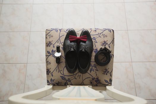 men's shoes with butterfly tie on a chair