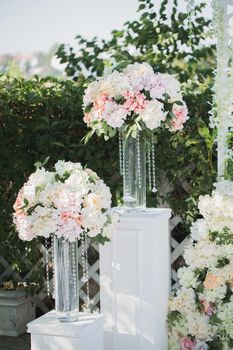 Beautiful wedding ceremony in the park. Decor of flowers and crystal beads.