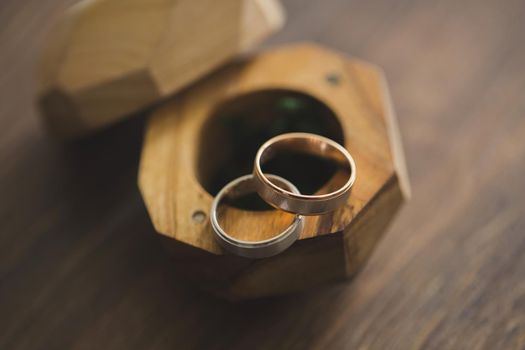 Wedding rings in a wooden box on the table.