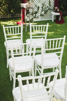 Beautiful white wedding chairs at the ceremony in the Park.