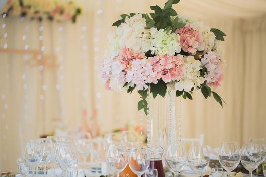 Vases with flowers on the wedding table.