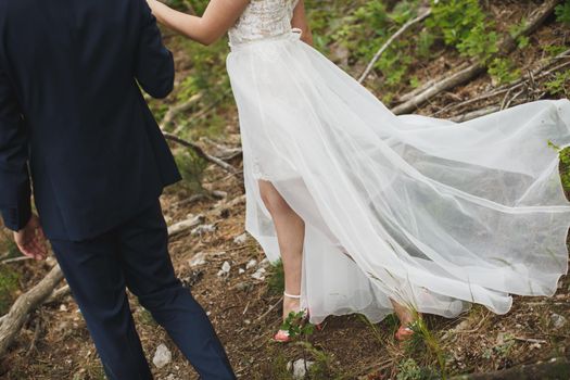 Bride and groom walking together holding their hands.