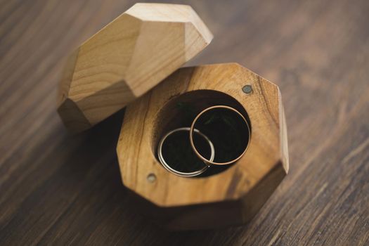 Wedding rings in a wooden box on the table