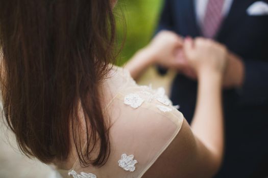 Bride and groom walking together holding their hands.