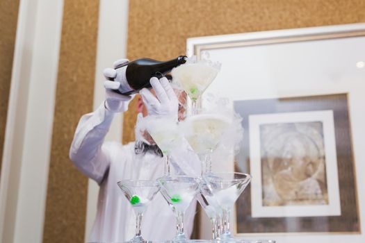 A waiter pours alcohol into glasses at a Banquet.