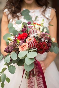 Wedding bouquet in the hands of the bride in boho style.