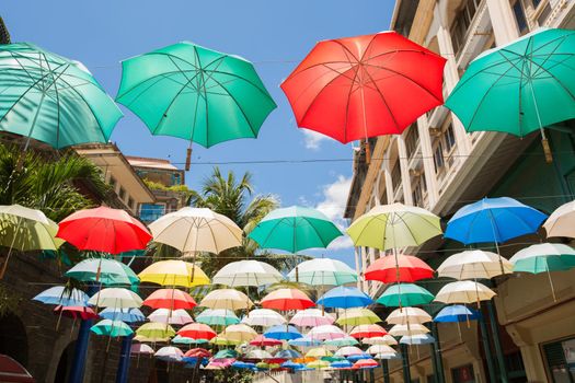 Multi-colored umbrellas background. Colorful umbrellas floating above the street. Street decoration.