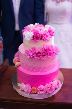 Pink wedding cake with fresh flowers. Ombre.