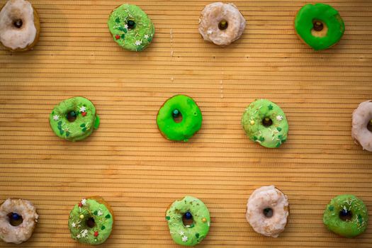 Decor of glazed donuts on a wooden background.