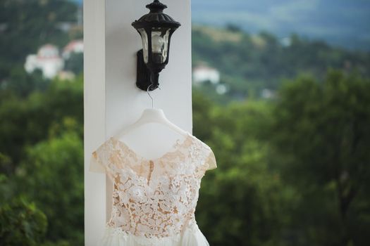 wedding dress hanging on a balcony on a background of snow-capped mountains