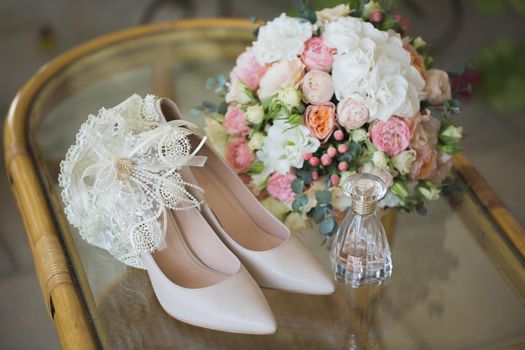 Wedding shoes with bouquet of flowers and perfume